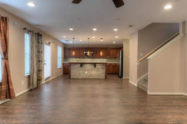 a open kitchen with stainless steel appliances granite countertop a refrigerator and a stove top oven