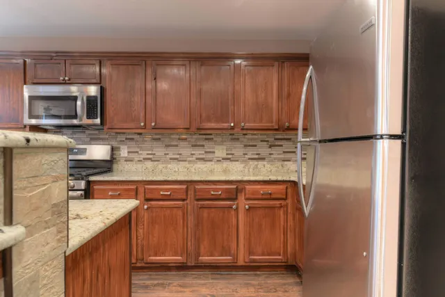 a kitchen with a refrigerator sink and cabinets