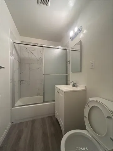a bathroom with a granite countertop toilet sink and shower