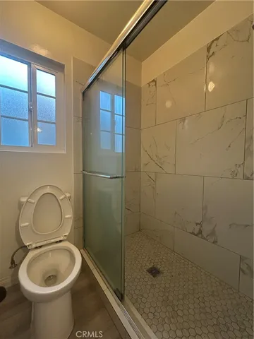 a bathroom with a toilet and a shower