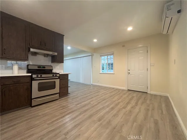 a kitchen with granite countertop a stove a sink and a microwave