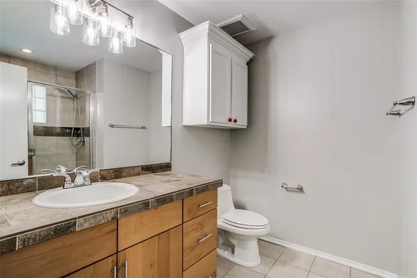 a bathroom with a granite countertop sink toilet and mirror