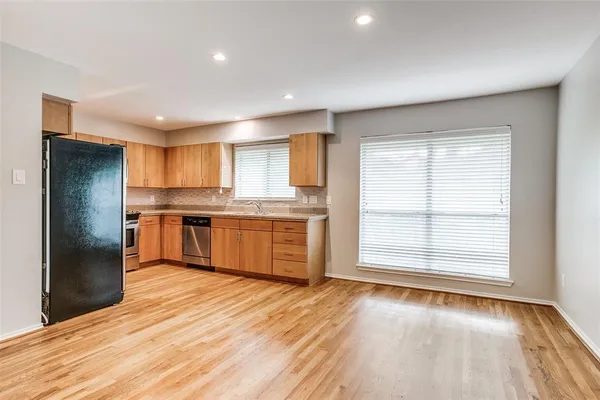 a kitchen with stainless steel appliances granite countertop a refrigerator and a sink