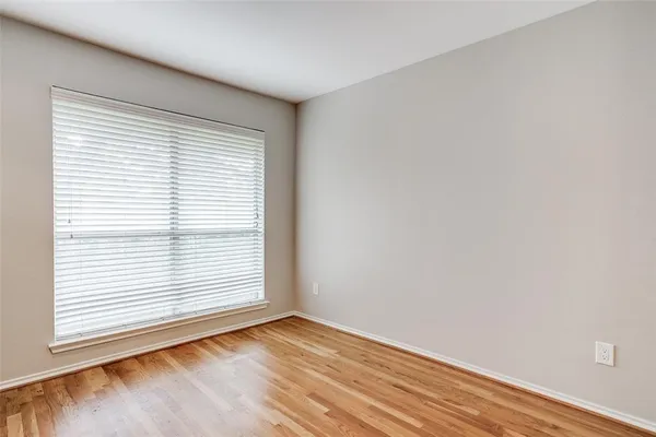 an empty room with wooden floor and a window