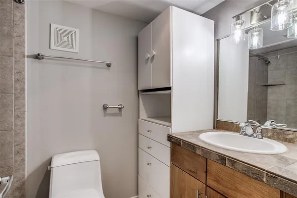 a bathroom with a granite countertop sink toilet and shower