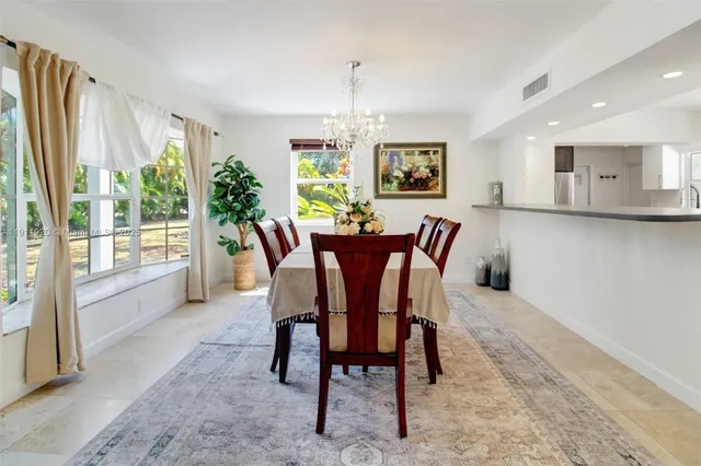 a kitchen with a sink dining table and chairs
