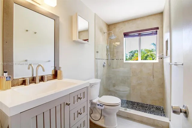a view of a hallway with wooden floor and a bathroom