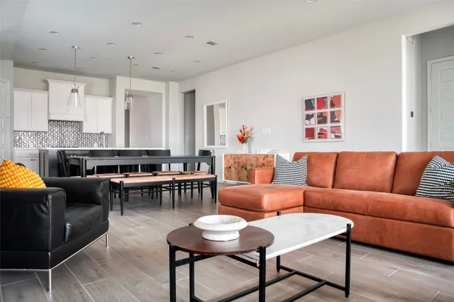 a living room with furniture a fireplace and a kitchen view