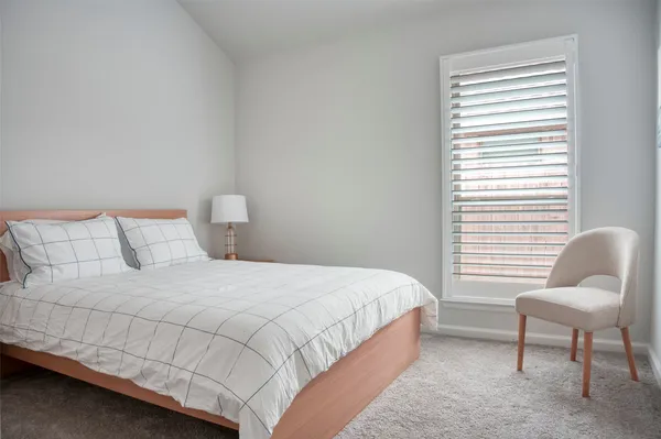 a bedroom with a bed chair and window