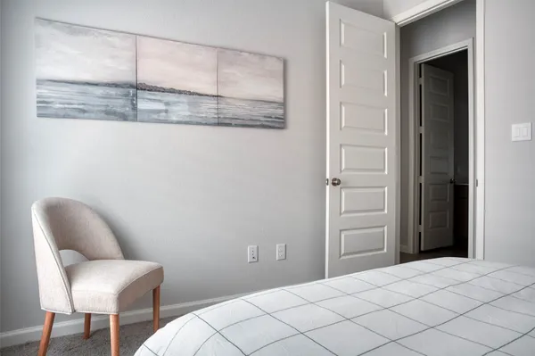 a bedroom with a chair and a chair