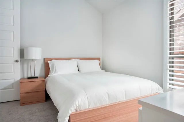 a bedroom with a bed and a large window