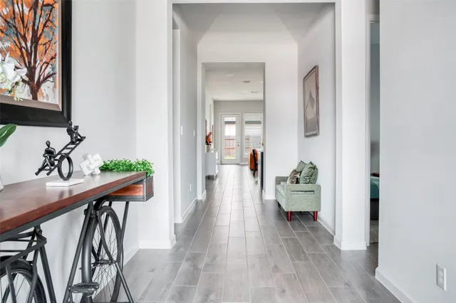 a view of a hallway with furniture and wooden floor