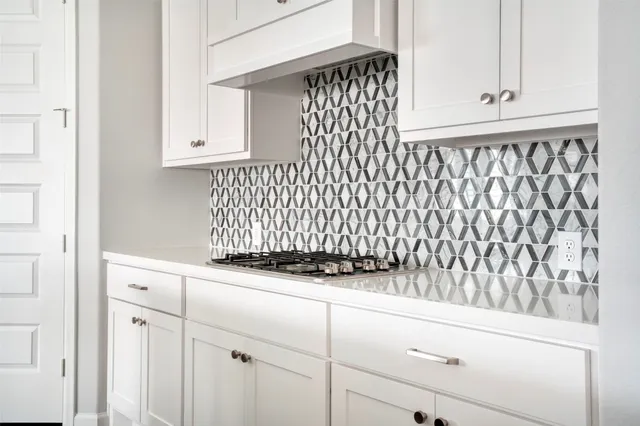 a kitchen with white cabinets and sink