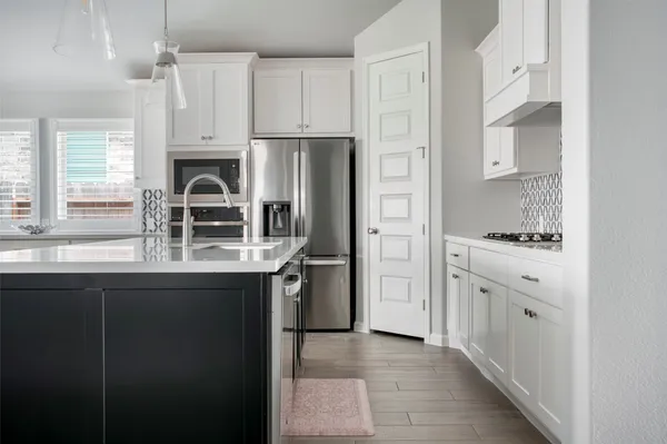 a kitchen with stainless steel appliances a refrigerator sink and cabinets