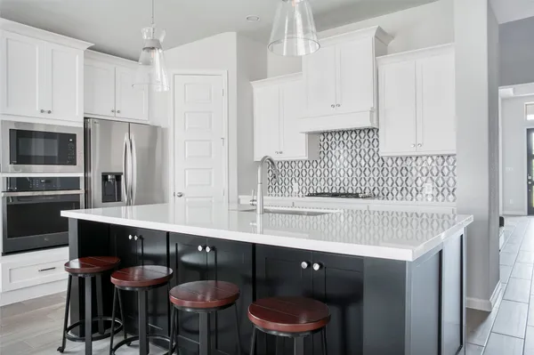 a kitchen with stainless steel appliances a sink and a refrigerator