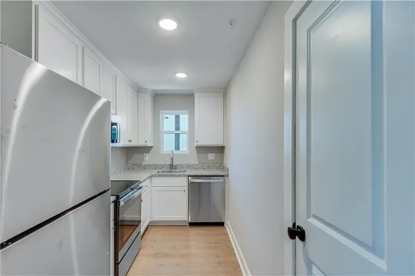a kitchen with white cabinets and white appliances