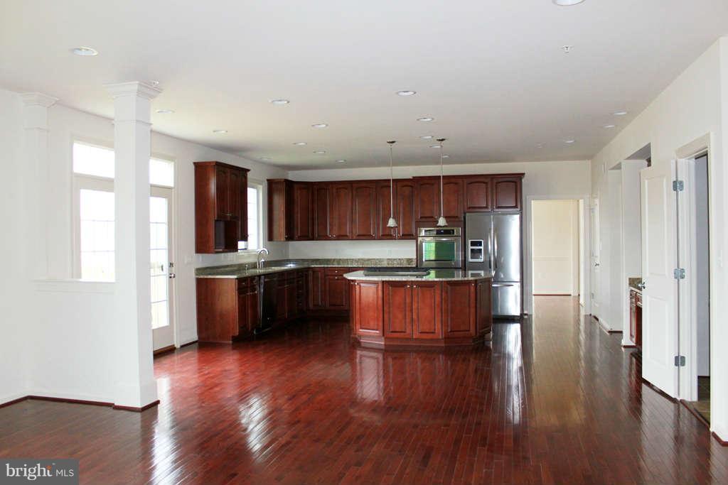 13333 Redspire Drive Silver Spring, MD 20906 - Photo 7 of 30 a kitchen with stainless steel appliances kitchen island wooden cabinets and granite counter tops