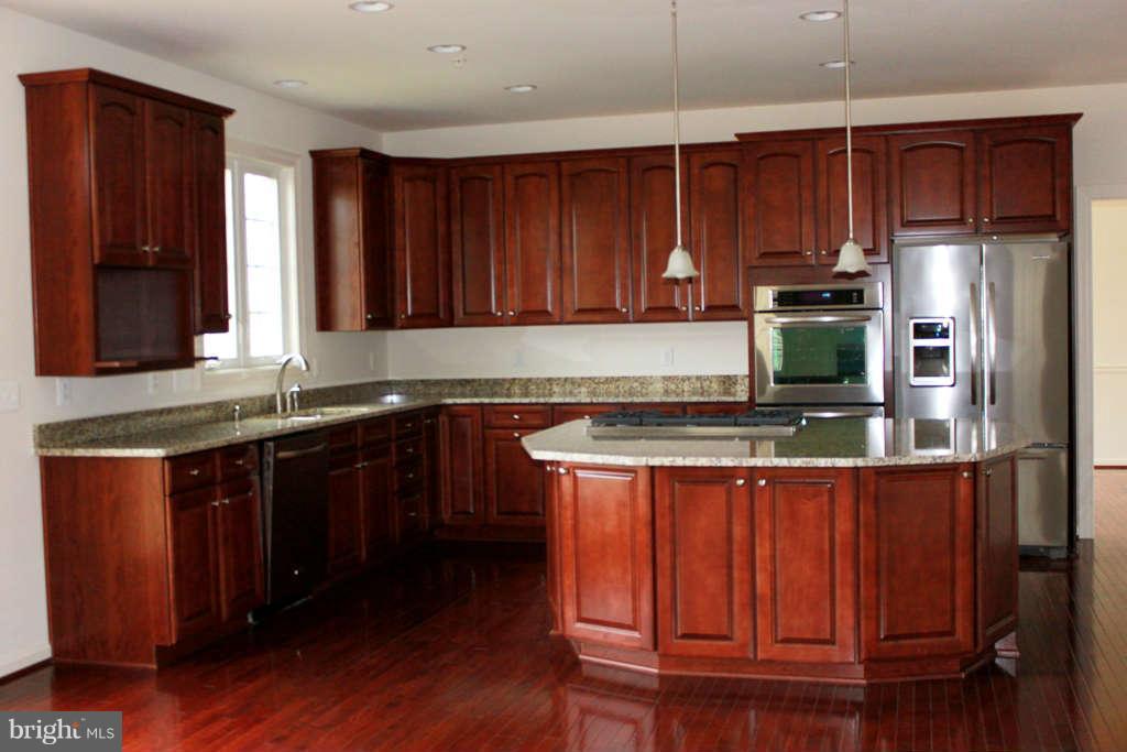 13333 Redspire Drive Silver Spring, MD 20906 - Photo 8 of 30 a kitchen with stainless steel appliances granite countertop wooden cabinets a stove top oven a sink and dishwasher