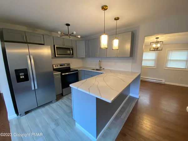 a kitchen with stainless steel appliances granite countertop a sink a refrigerator and a stove