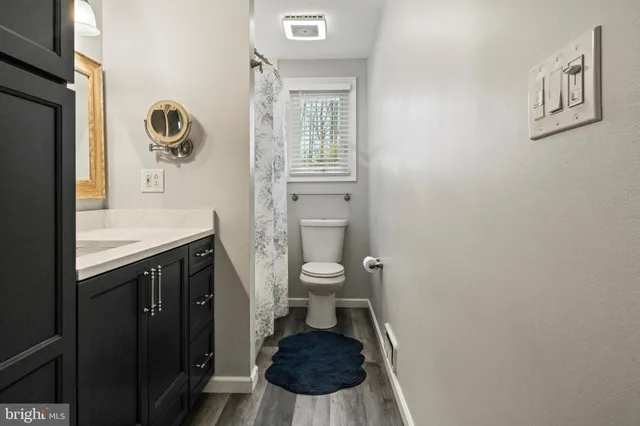 a bathroom with a toilet a sink and mirror