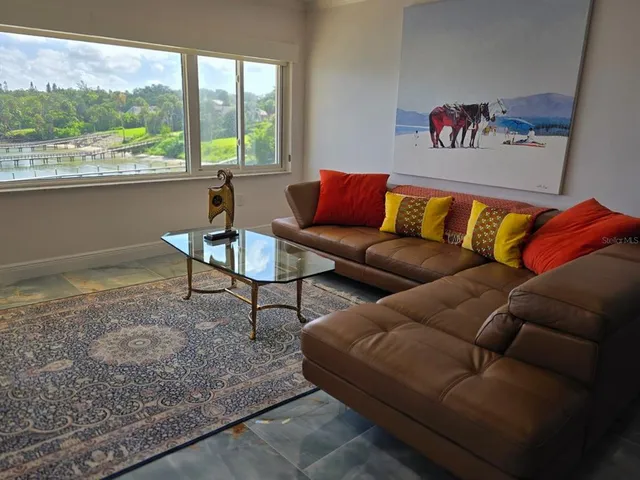 a living room with furniture and a floor to ceiling window