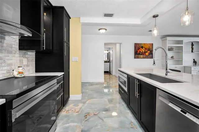 a kitchen with stainless steel appliances granite countertop a refrigerator and a stove
