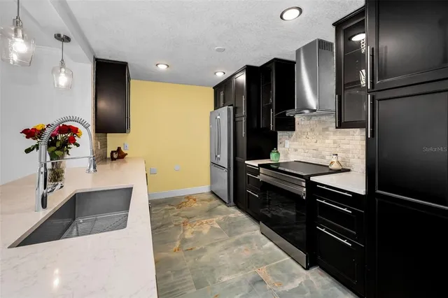 a kitchen with granite countertop a refrigerator and a sink