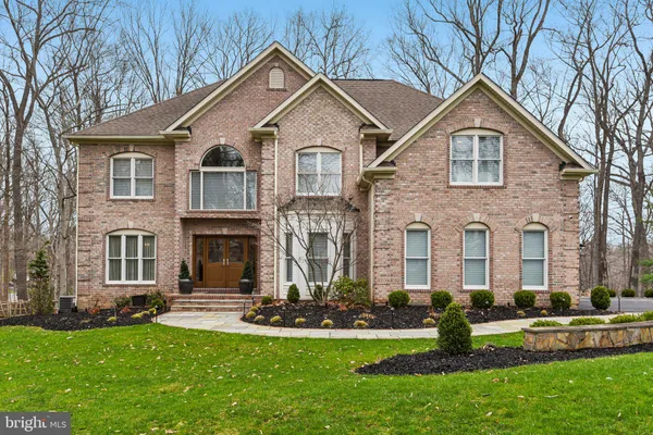 a front view of a house with a yard and trees