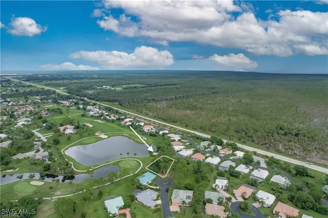 an aerial view of residential houses with outdoor space and trees