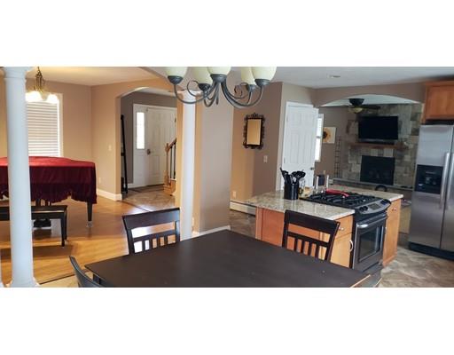 a kitchen with stainless steel appliances granite countertop a stove top oven a sink and a dining table