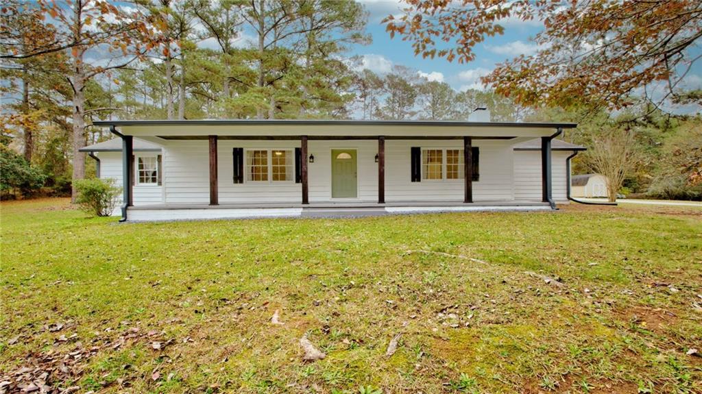 Ranch-style house with a front yard and a porch