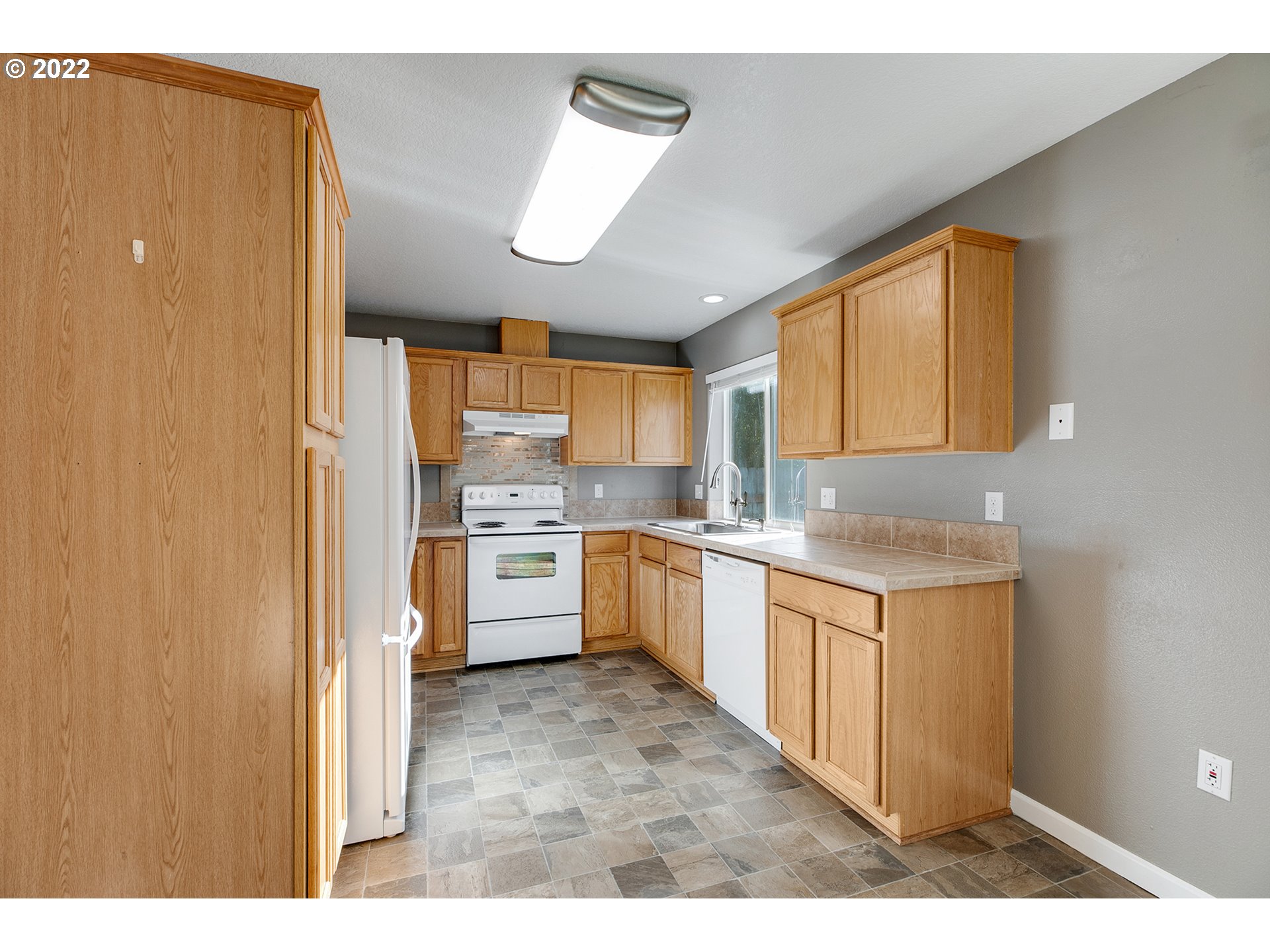 517 Northeast Mariners Loop Portland, OR 97211 - Photo 11 of 30 a kitchen with a sink cabinets stainless steel appliances and a window
