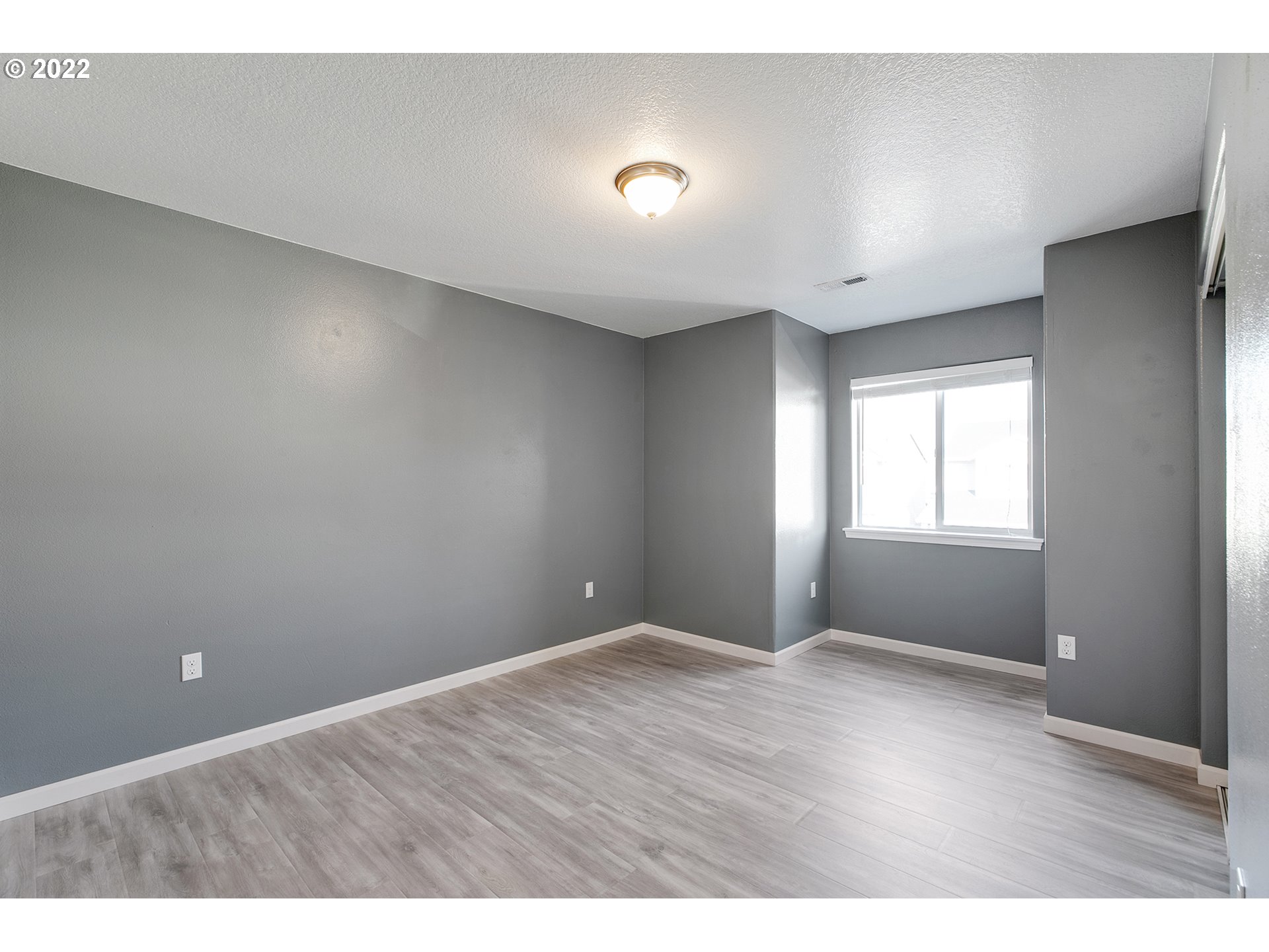 517 Northeast Mariners Loop Portland, OR 97211 - Photo 18 of 30 a view of an empty room with wooden floor and a window