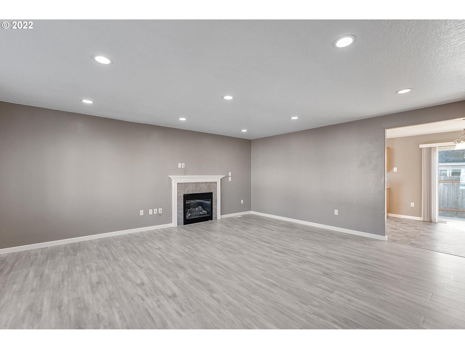517 Northeast Mariners Loop Portland, OR 97211 - Photo 4 of 30 a view of an empty room with wooden floor and fireplace