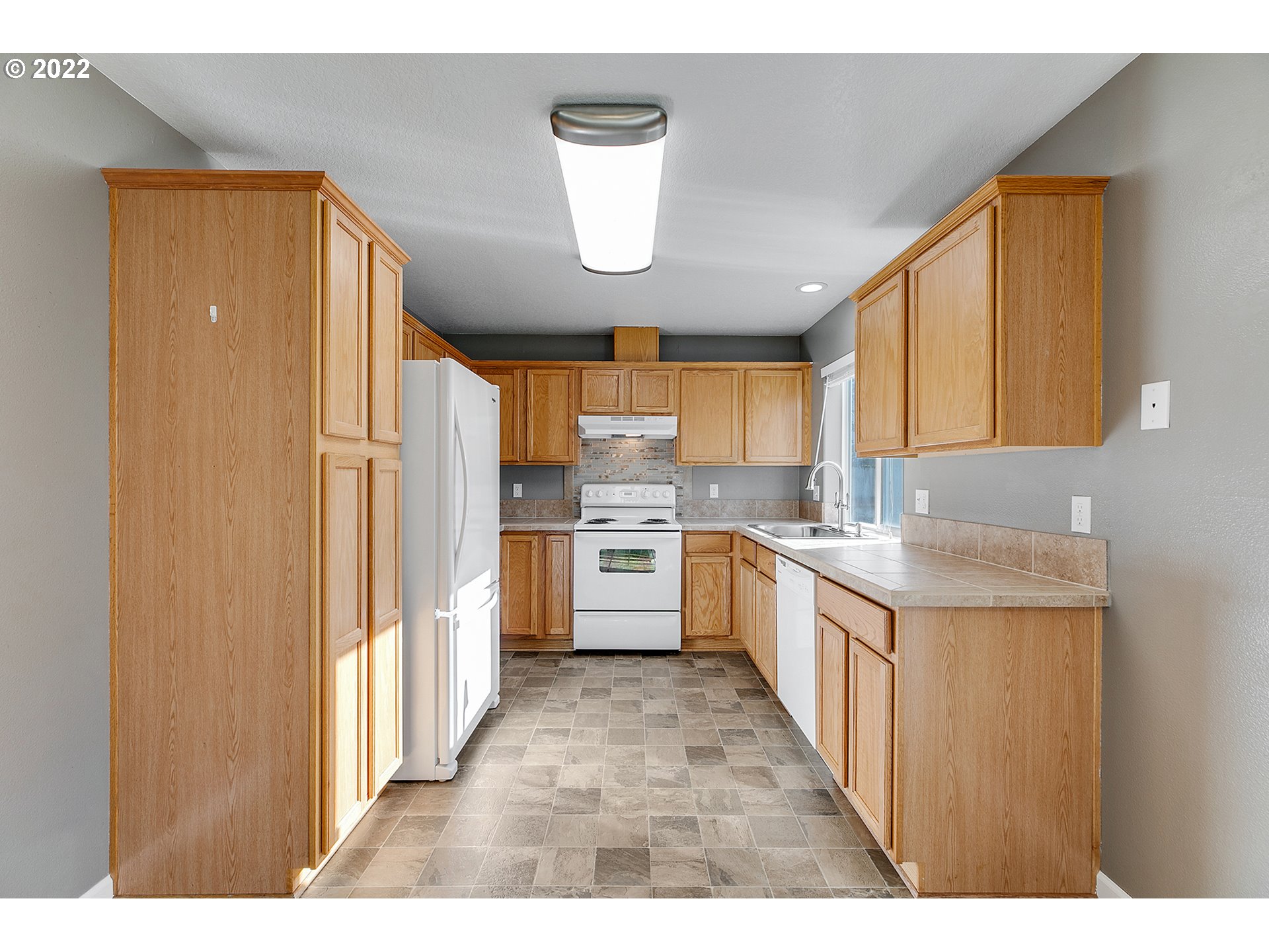 517 Northeast Mariners Loop Portland, OR 97211 - Photo 10 of 30 a large kitchen with kitchen island a sink a counter top space stainless steel appliances and cabinets