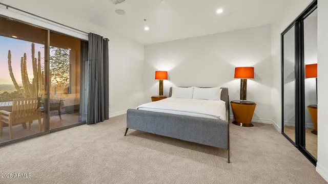 a bedroom with a balcony a bed and a lamp