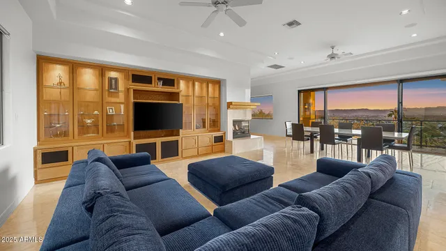 a living room with furniture tv and large windows