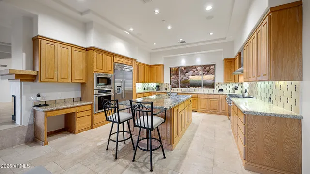 a large kitchen with cabinets table and chairs