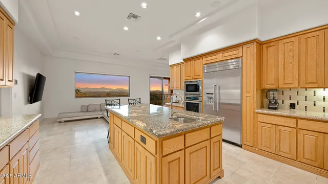 a kitchen with stainless steel appliances granite countertop a sink and a refrigerator