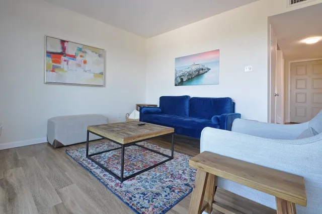 a living room with furniture a rug and a wall painting