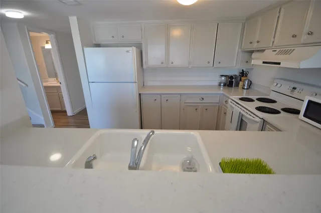 a kitchen with a refrigerator sink and cabinets