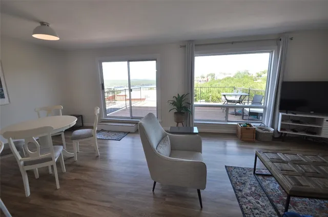 a living room with furniture a flat screen tv and a large window