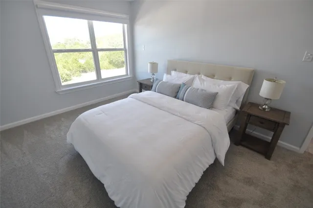 a large bed sitting in a bedroom next to a window