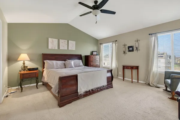 a spacious bedroom with a bed and a chandelier