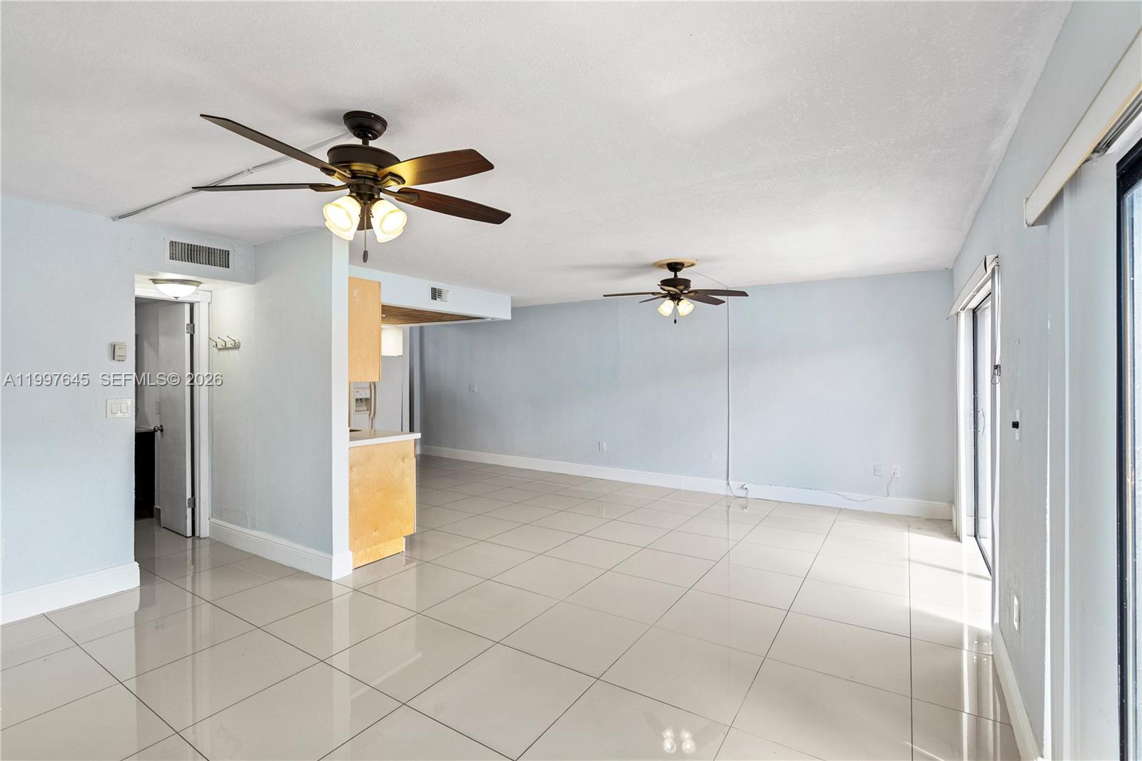 8748 Southwest 154th Cir Place, Unit 6N Miami, FL 33193 - Photo 11 of 34 a view of a room with a ceiling fan and refrigerator