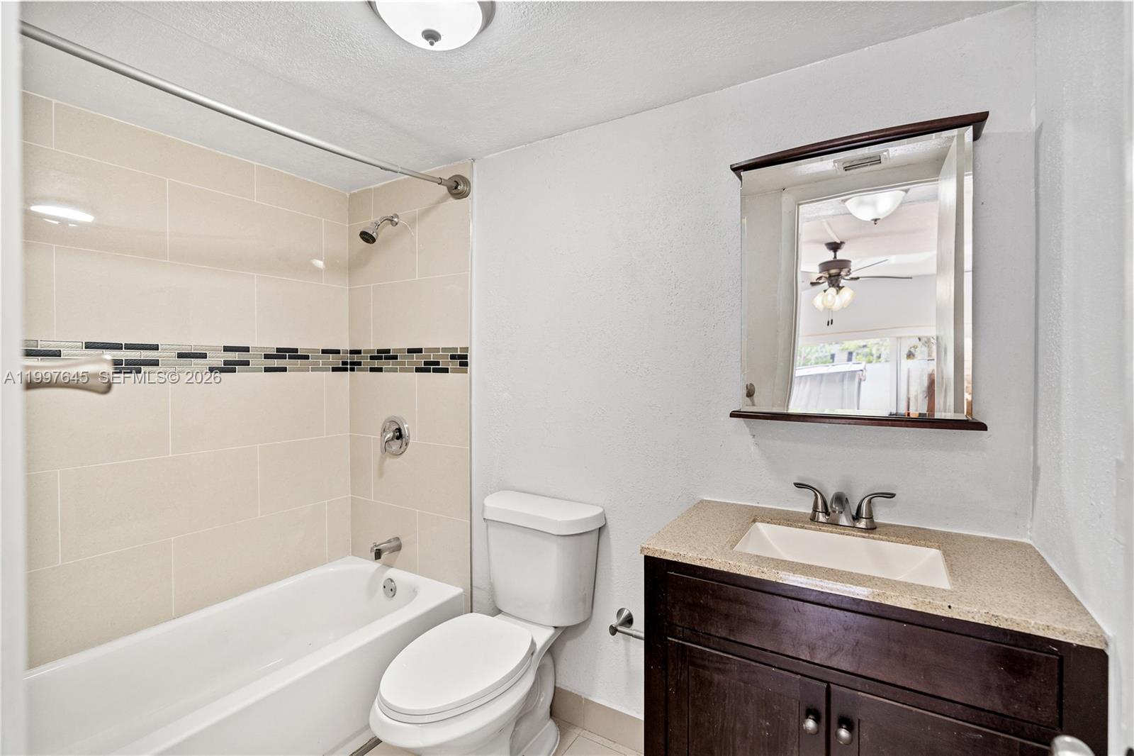 8748 Southwest 154th Cir Place, Unit 6N Miami, FL 33193 - Photo 12 of 34 a bathroom with a sink vanity granite toilet tub and shower