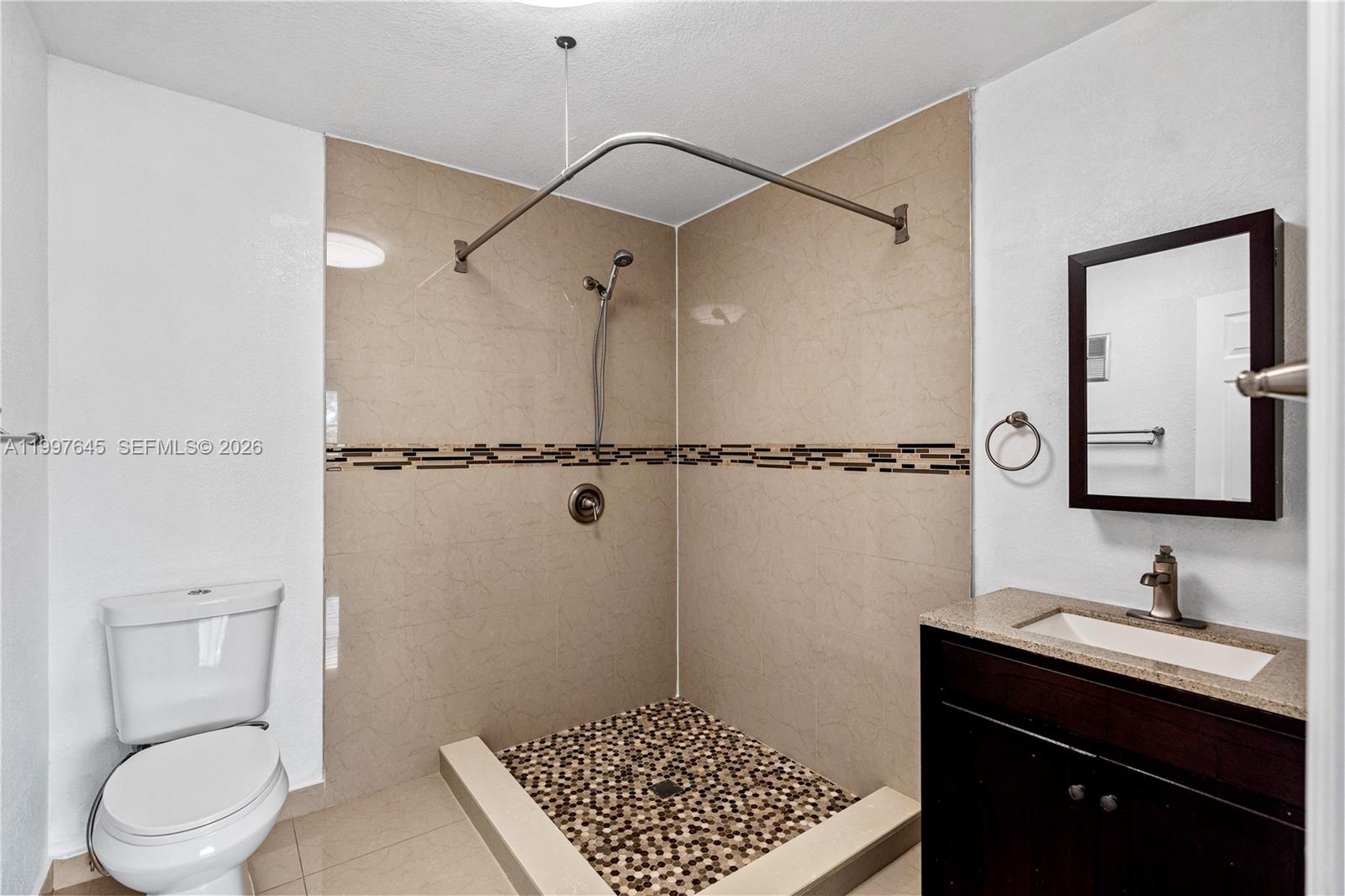 8748 Southwest 154th Cir Place, Unit 6N Miami, FL 33193 - Photo 21 of 34 a bathroom with a granite countertop sink toilet and shower