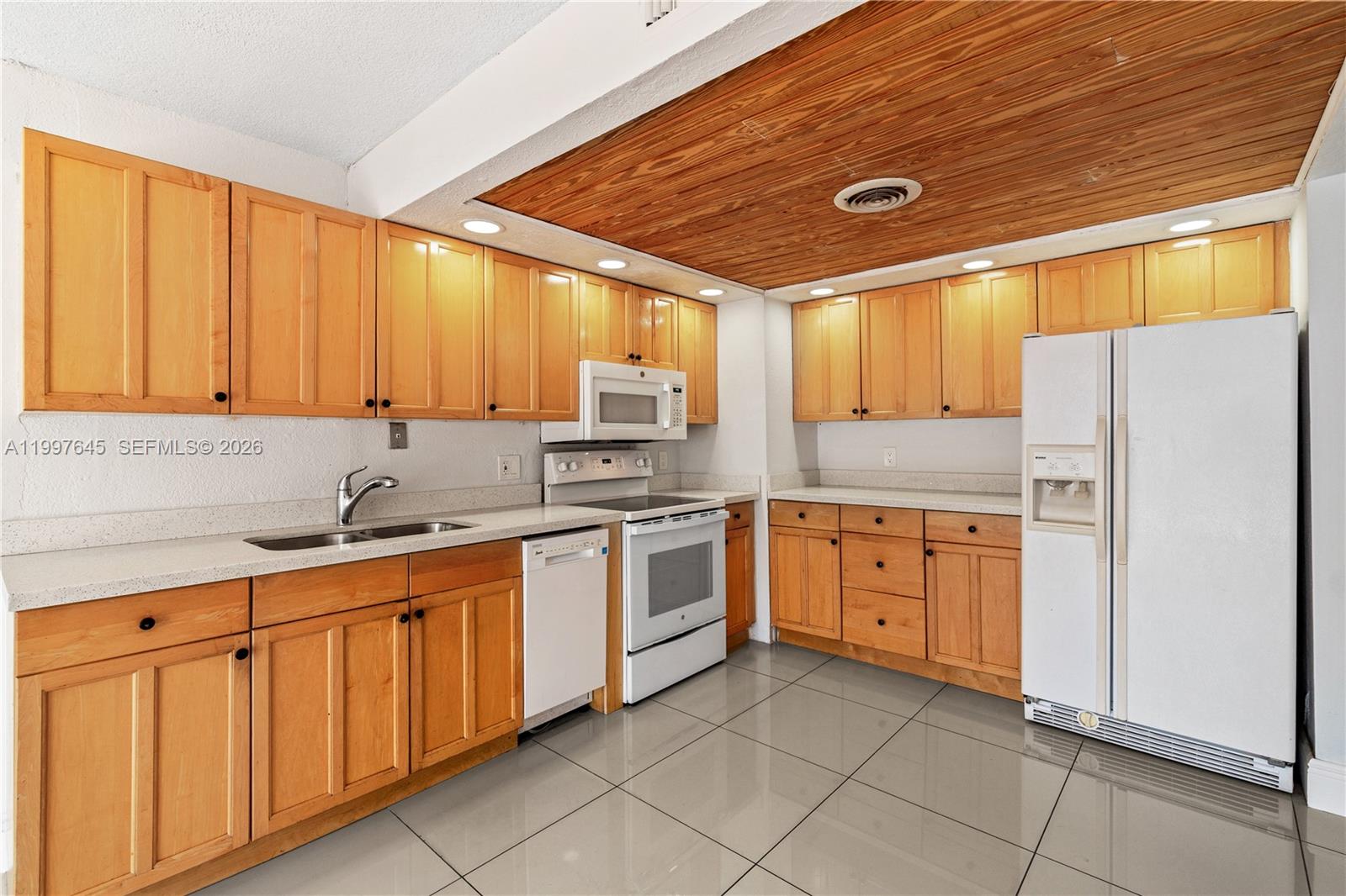8748 Southwest 154th Cir Place, Unit 6N Miami, FL 33193 - Photo 7 of 34 a kitchen with stainless steel appliances granite countertop a refrigerator sink and cabinets