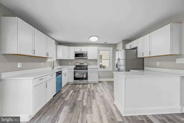 a kitchen with white cabinets and stainless steel appliances