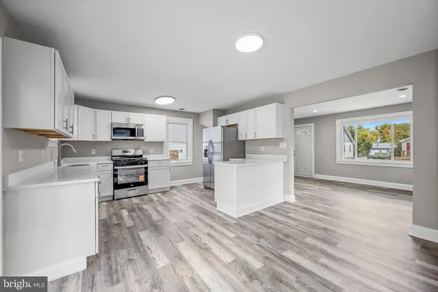 a kitchen with cabinets and wooden floor